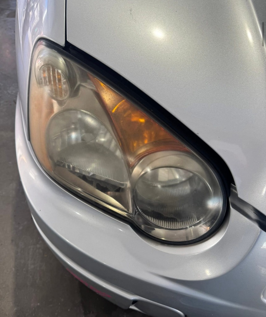 Foggy yellow oxidized car headlight before UV restoration and protective sealant service in Clearfield UT